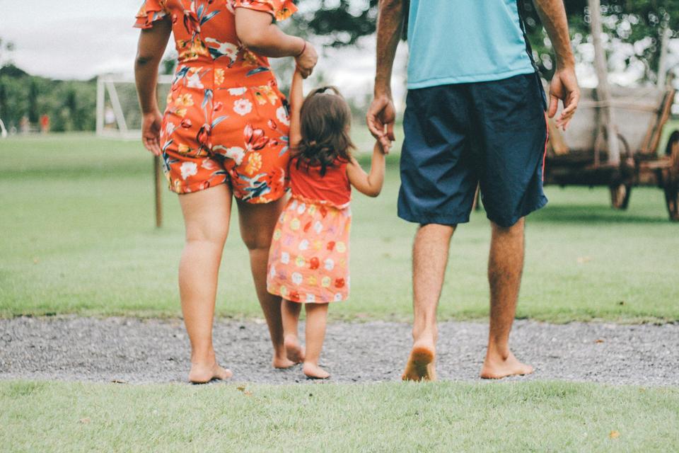 A family walks across a park.